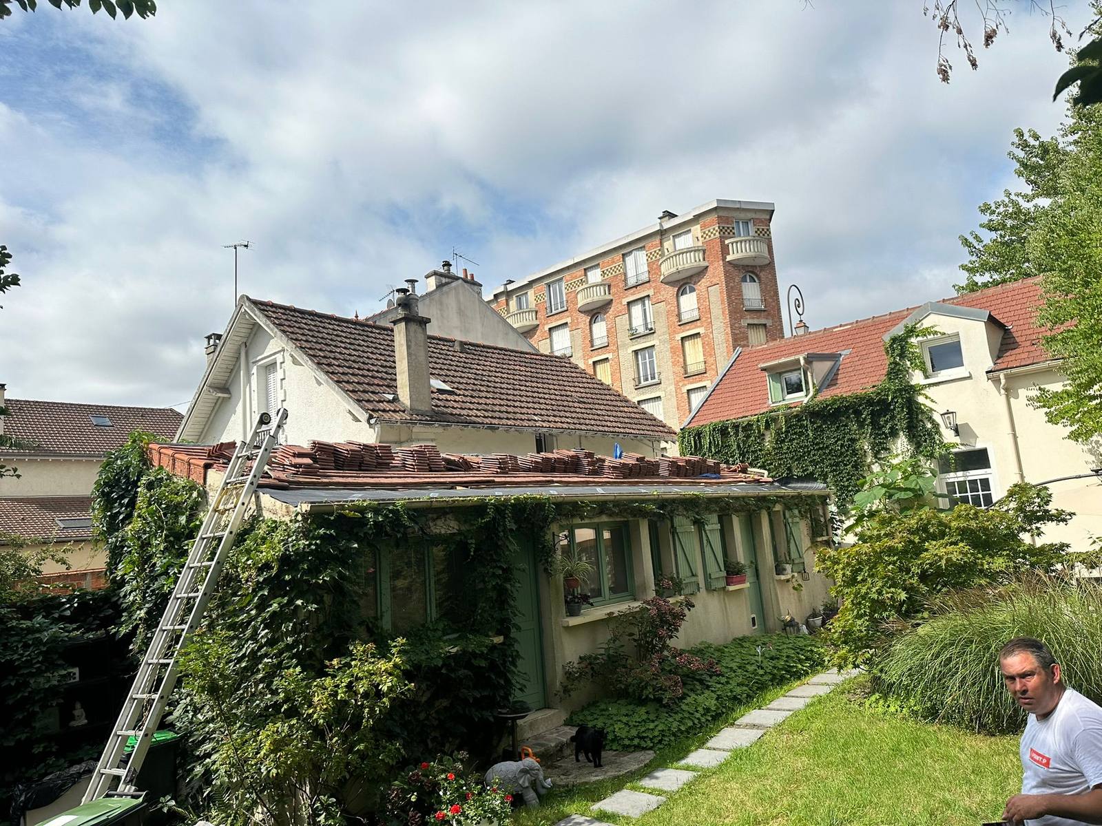 Chantier de rénovation de toiture sur une maison avec jardin.