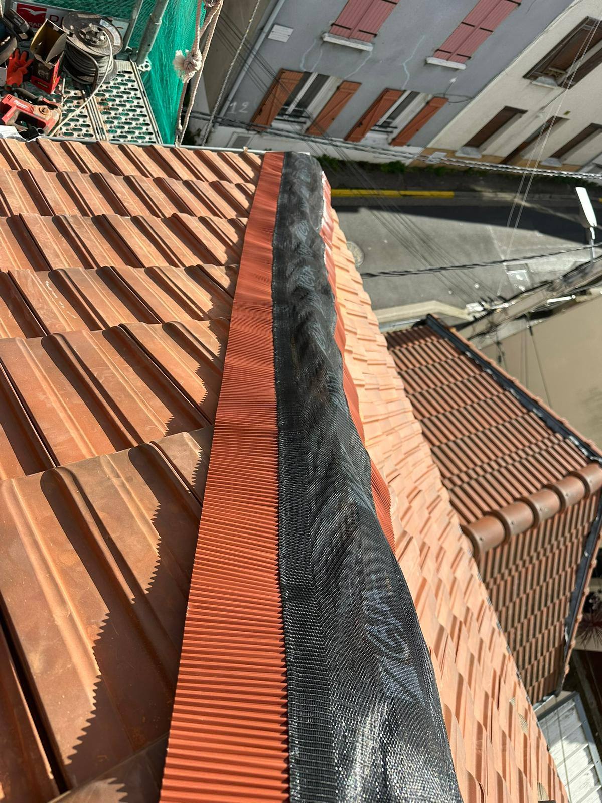 Faîtage de toiture rénové le long d'un mur maçonné.