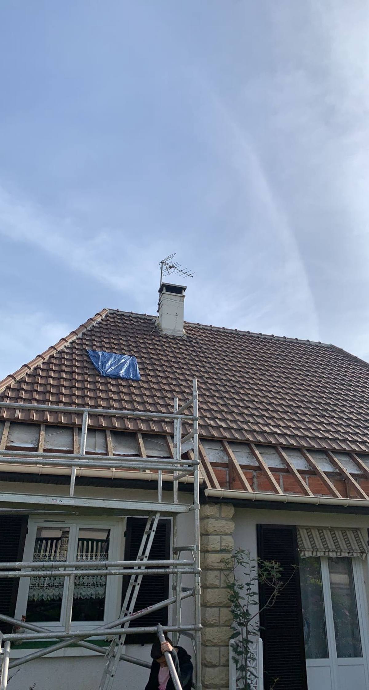 Toiture en tuiles et cheminée vues depuis le chantier.